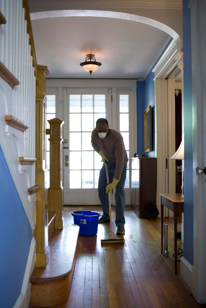 A move in cleaning professional mopping the entry.
