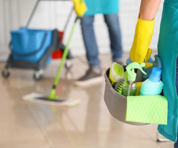 Recurring cleaning crew, one cleaner mops the floor while the other holds the bucket full of cleaning supplies.
